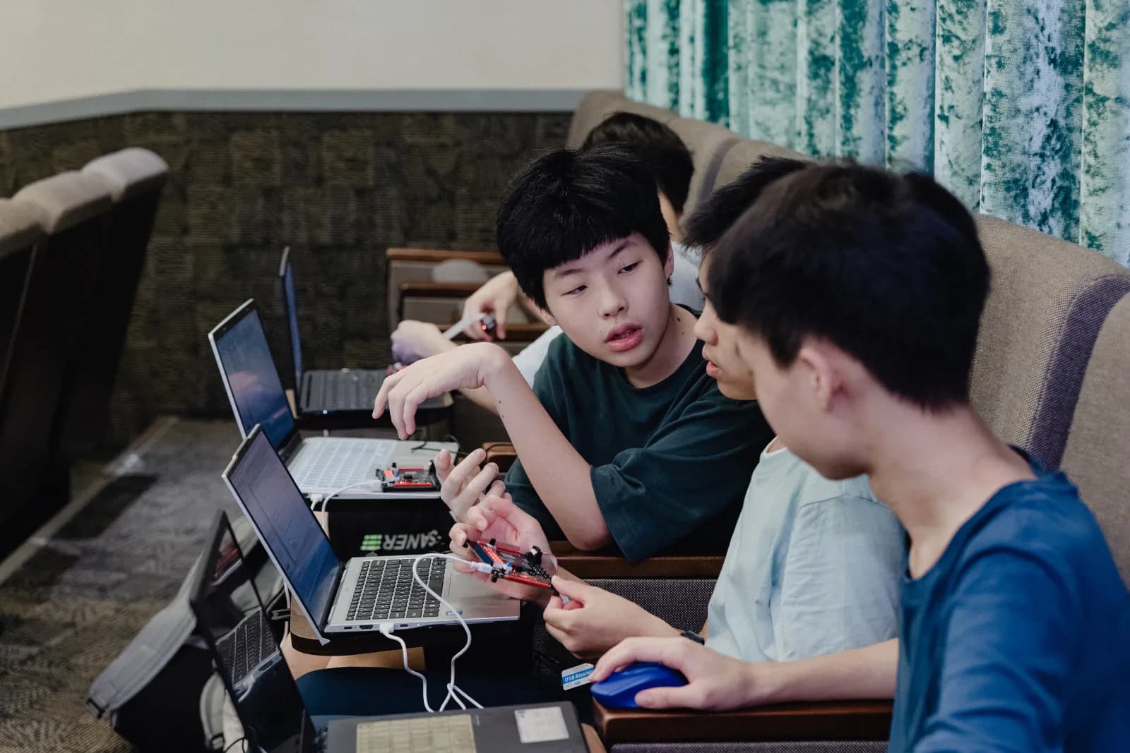 學員手拿 FPGA 開發板與小隊討論